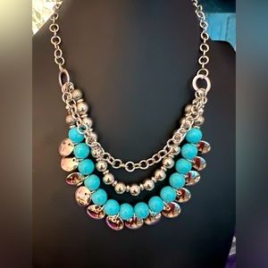 Silver chain with Blue Crackle Stone and several silver circular disks.